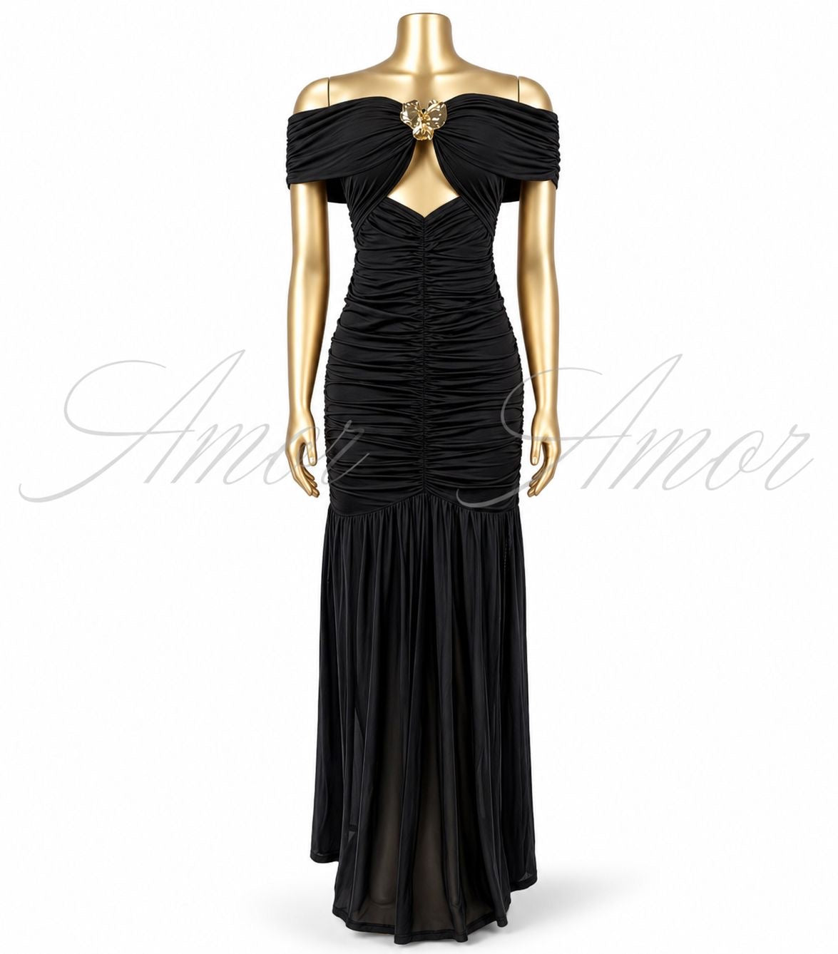 Vestido largo disponible en color negro, rojo y blanco. Diseño con hombros descubiertos, detalle metálico al frente, fruncido que estiliza la silueta y abertura en pierna. Elegante y sofisticado.